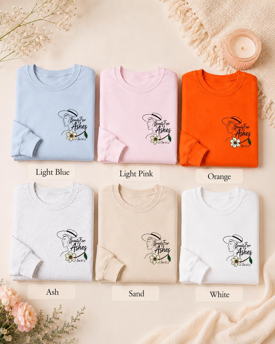 Beauty for Ashes sweatshirts folded on a styled table in six colours, inspired by Isaiah 61:3